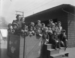 School children and teacher posing for a photograph on a playground, 1951