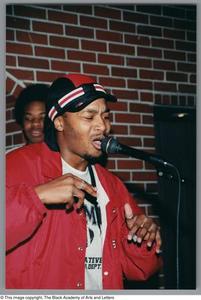 Photograph of a man passionately singing into a microphone