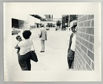 Woman holding baby on street corner