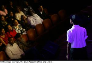 Audience members watching a performer