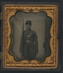 [Unidentified soldier in Union frock coat and forage cap with bayoneted musket and cap box in front of painted backdrop showing curtain]