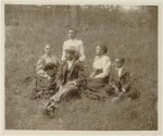 [African American family posed for portrait seated on lawn]