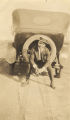 Young African American man sitting in the spare tire on the back of an automobile.