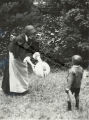 Pilgrim woman offering a ball to a child