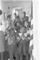 Teacher and students saying a prayer in a classroom.