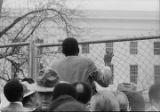 Legislator climbing a fence around the Capitol in Montgomery, Alabama, in an attempt to remove the Confederate flag from the dome.