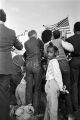 Child standing behind journalists and photographers during the 20th anniversary reenactment of the Selma to Montgomery March in Selma, Alabama.