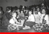 Children seated on the floor with their craft projects