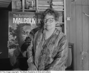 Laura Jean Lacy posing with illustrated cover of Malcolm X