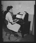 Manning Office of War Information's "nerve center." A new field of employment was opened to Negroes recently when six colored girls were given skilled jobs in the Teletype room of the Office of War Information. The young women, trained by OWI at the American Telephone and Telegraph School in Washington, D.C., operate machines which receive and send official war information to all parts of the country. Miss Harriette Thorne is shown operating an ASR teletype machine in the Bureau of Publications and Graphics