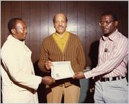 Three American Postal Workers Union members holding a certificate