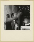 [African American man, hands waving in front of face, preaching passionately from a lectern at a store front church in Buffalo, New York]