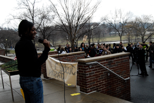 Thumbnail for Justice for Jason rally at UMass Amherst: speaker on the south deck of the Student Union building at the rally in support of Jason Vassell