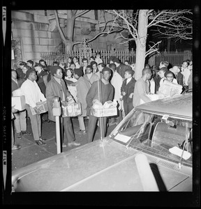 Groups of people with provision boxes walking out of the Boston University Administration Building as their 12 hour sit-in ends