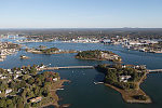 An October 2017 aerial view of the historic seaport of Portsmouth, New Hampshire, the largest city along the shortest coastline (18 miles) of any U.S. state. The focus is on small islands in the Piscataqua River, with the town of New Castle (also in New Hampshire) in the distance. Portsmouth also lies directly across another stretch of the river from Kittery, the southernmost point of the state of Maine