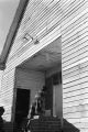 People entering a wooden church building in rural Prattville, Alabama, probably for a meeting of the Autauga County Voters Association.