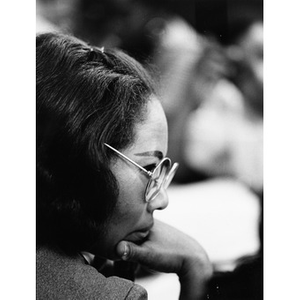 Profile of an unidentified female staff member of La Alianza Hispana, turned to the right and wearing eyeglasses.