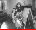 Nursery teacher Ramona Heindt with children at an easel