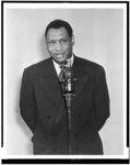 [Paul Robeson, half-length portrait, facing front, standing before microphone shaped like a bottle of Coca-Cola]