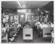 Mississippi State Sovereignty Commission photograph of the interior of Stanley's Cafe showing men eating while seated at tables, booths and counter, Winona, Mississippi, 1961 November 1