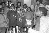 Children in the group "Buds of Promise" from Mt. Zion AME Zion Church in Montgomery, Alabama, singing to an elderly woman in her home.