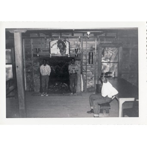 Three boys pose by the fireplace in a cabin at Breezy Meadows Camp