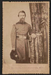 [Captain John Wilson of Co. C, 8th Kentucky Infantry Regiment (Union), in uniform with sword; revolver and book rest on table]