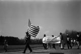 Man carrying an American flag during the 20th anniversary reenactment of the Selma to Montgomery March.