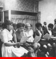 Young women singing with sheet music