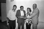 Guy Crowder holding an award while posing with his wife and son, Los Angeles, 1987