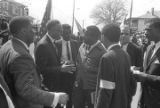 Fred Shuttlesworth, Ralph Abernathy and others talking in the street at Martin Luther King, Jr.'s funeral.