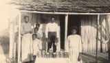 African American family standing around a display of preserves in front a cabin in Pickens County, Alabama.