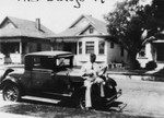 Man sitting on car playing banjo