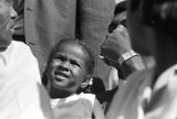 Muhammad Ali with a little girl, sitting in the bleachers during homecoming activities for Alabama State College on Thanksgiving Day in Montgomery, Alabama.