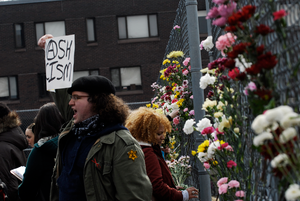 Justice for Jason rally at UMass Amherst: protesters in support of Jason Vassell placing flowers in a chain link fence