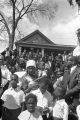 Onlookers along the side of the street in front of a house during the funeral procession for Martin Luther King, Jr.