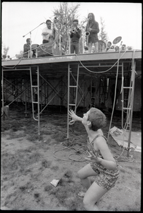 May Day concert and demonstrations: couple dancing below concert stage while Charles Mingus performs