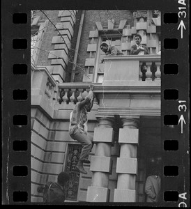 Student climbs up Boston University administration building during sit-in