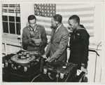 Bugler Leonard Madden (left) and sailor Clarence Brooks (right) record talking letter records to families at Chappie Willet Recording Studios, New York City, with a Willet arranger, circa 1942