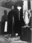 Washington, D.C. Reverend Vondell Gassaway, pastor of the St. Martin's Spiritual Church standing in a bowl of sacred water banked with roses, each of which he blesses and gives to a member who has been annointed and prayed for by a long line of disciples during the annual "flower bowl demonstration"