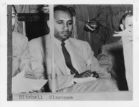 Mississippi State Sovereignty Commission photograph of a seated Clarence Mitchell dressed in a suit and looking downward, Washington, D.C., 1950s