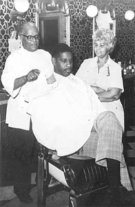 Sylvester and Pauline Young working at Young Brothers Barber Shop and Satin Doll Beauty Salon, Minneapolis.