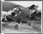 Seated in the rear cockpit, Gen. Dwight D. Eisenhower, Commander in Chief of A.F.H.Q., readies himself for the take off to fly back from the front lines. Piloting the plane is Maj. T.J. Walker, Fifth Army Artillery office, Venafro sector, Italy