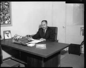 Doyle Mitchell at desk, Mar[ch] 1964 [cellulose acetate photonegative]