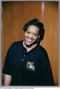 Medium shot photograph of a woman smiling and leaning to her right