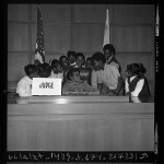 Thumbnail for African American children from underprivileged South Central area schools on judge's bench during courthouse tour in Los Angeles, Calif., 1971