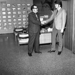 Two men shaking hands in a realtor's office, Los Angeles