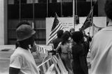 African American boys standing beside a police barricade at a United Klans of America march in Mobile, Alabama.