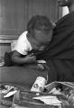 Young woman holding a baby while sitting on the porch of a house in Little Korea, a neighborhood in Birmingham, Alabama.